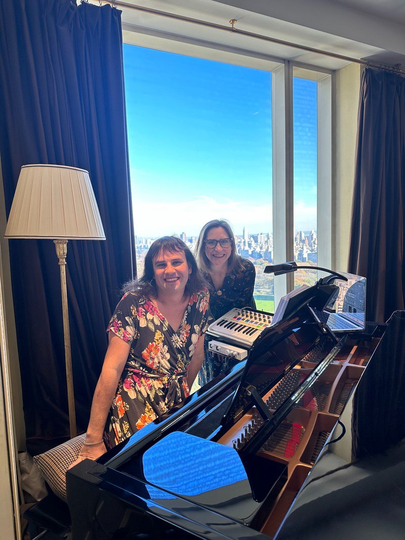 Kait and Bree at the piano with NYC skyline